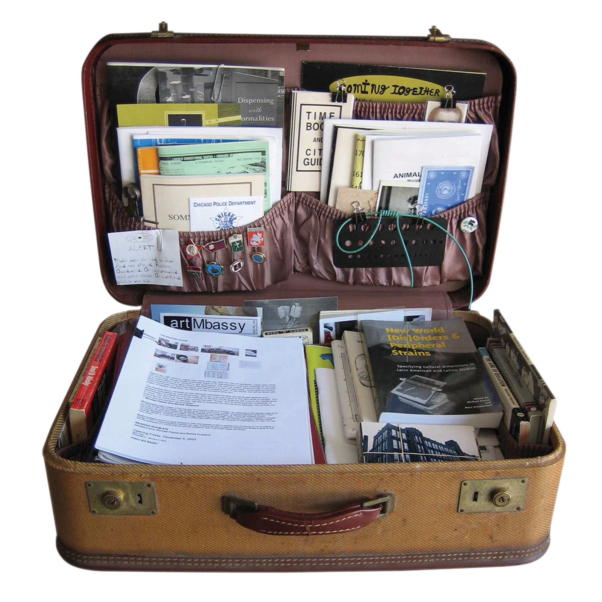An old suitcase filled with books, zines, handwritten notes, and other printed ephemera